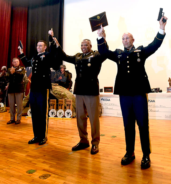 Noncommissioned Officer of the Year Staff Sgt. Mitchell Scofield, front right, and Soldier of the Year Cpl. Daniel D'Ippolito, front left, hoist their pistols into the air during the closing ceremony of the Army National Guard’s 2020 Best Warrior Competition at Camp Shelby, Mississippi, Sept 16. Command Sgt. Maj. John F. Sampa, middle, the command sergeant major of the Army National Guard, joins Scofield and D'Ippolito in celebrating their new victories. The two Soldiers will go on to compete in the 2020 All-Army Best Warrior Competition, slated to be held virtually later in the year.